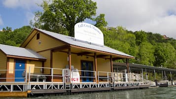 Een gebouw aan het water met een bord waarop staat: Fall Creek Marina, open voor publiek.