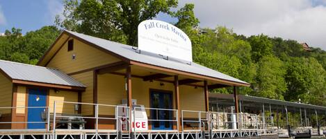 Un edificio frente al agua con un letrero que dice 'Fall Creek Marina Abierto al Público'.