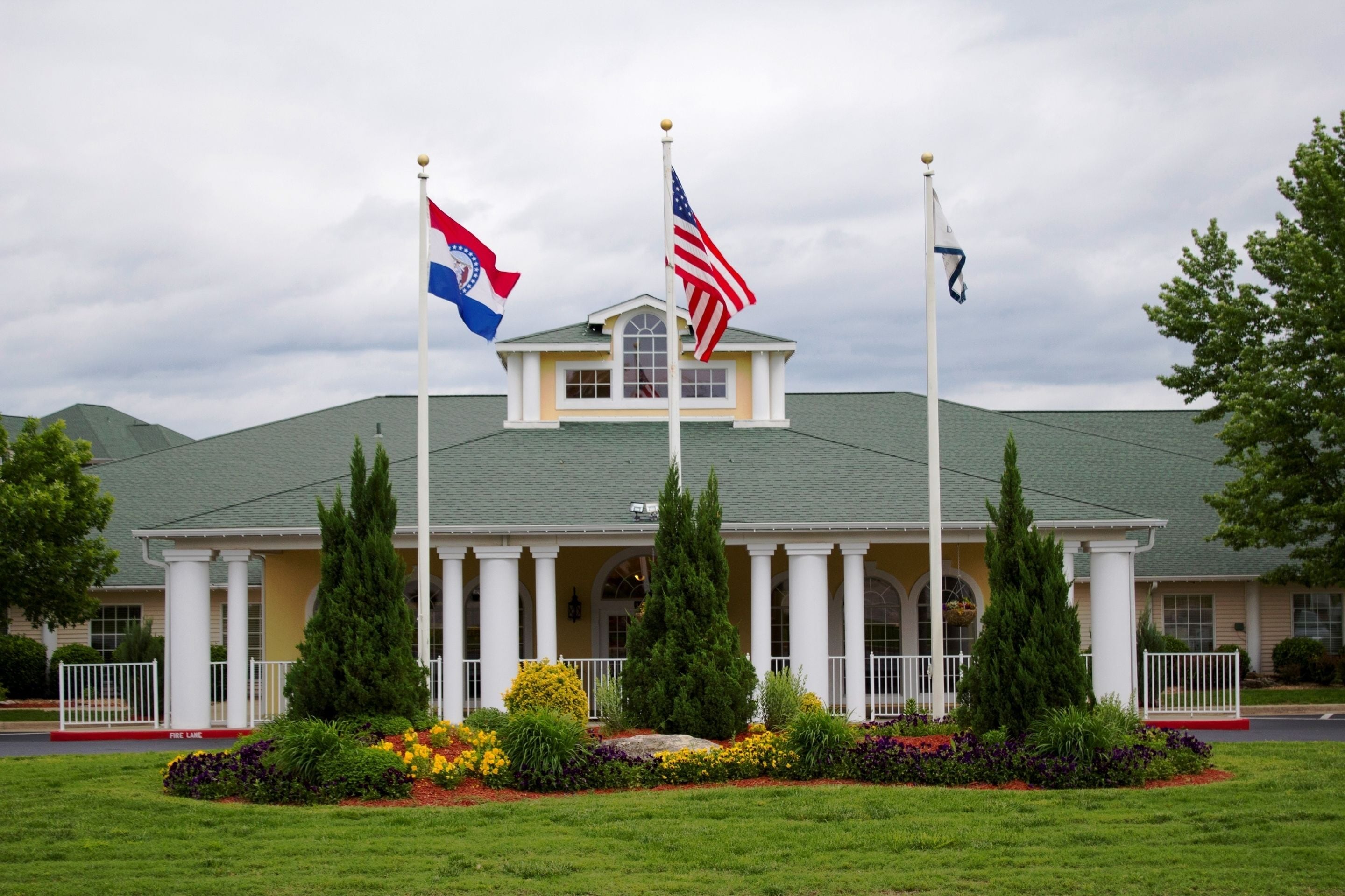 A building with a green roof, white columns, and a central entrance.