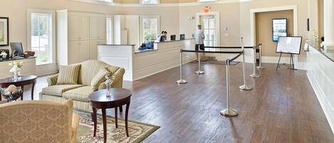 A spacious lobby with a reception desk, seating area, and a chandelier.