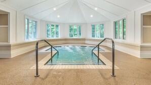 An indoor swimming pool with a clear view of the surrounding walls and windows.