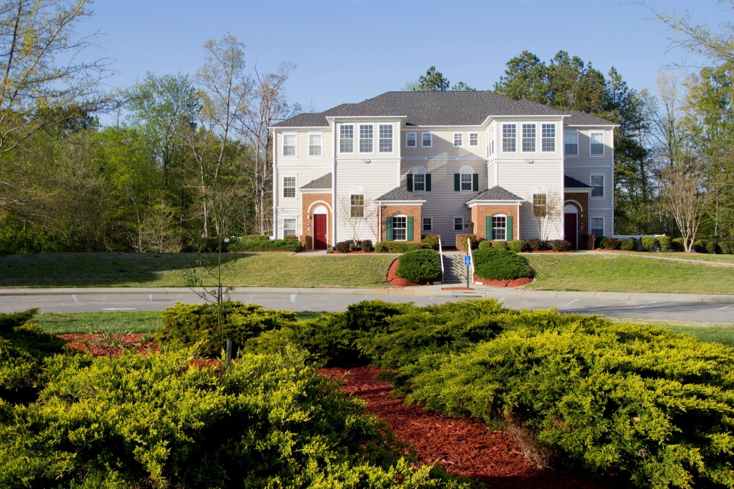 A two-story house with a front yard and a driveway.