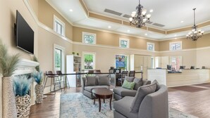 A spacious living room with a fireplace, a large TV, and a dining area with a bar.