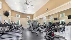 A gym with treadmills, weight machines, and a mirrored wall.