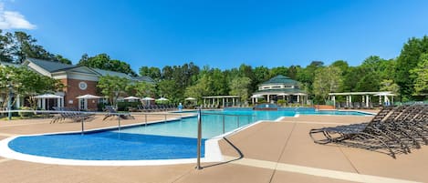 A pool area with lounge chairs and a building with a green roof.