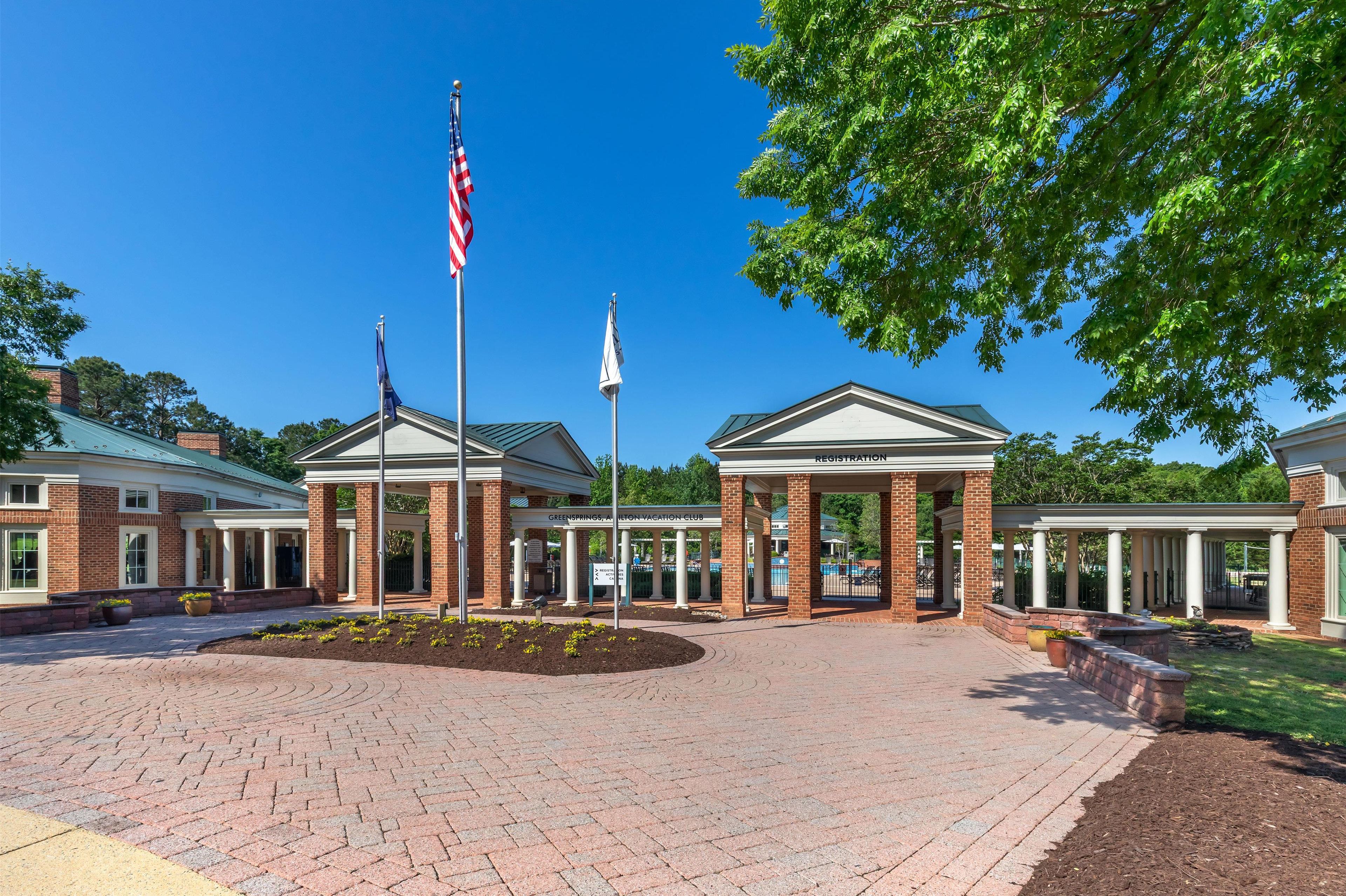 A brick building with a covered entrance and American flags.
