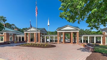 A brick building with a covered entrance and American flags.