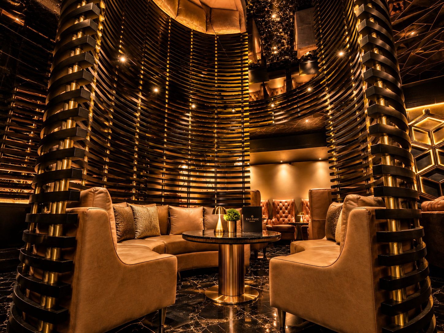 A luxurious interior with a curved wall design, a round table, and leather seating.