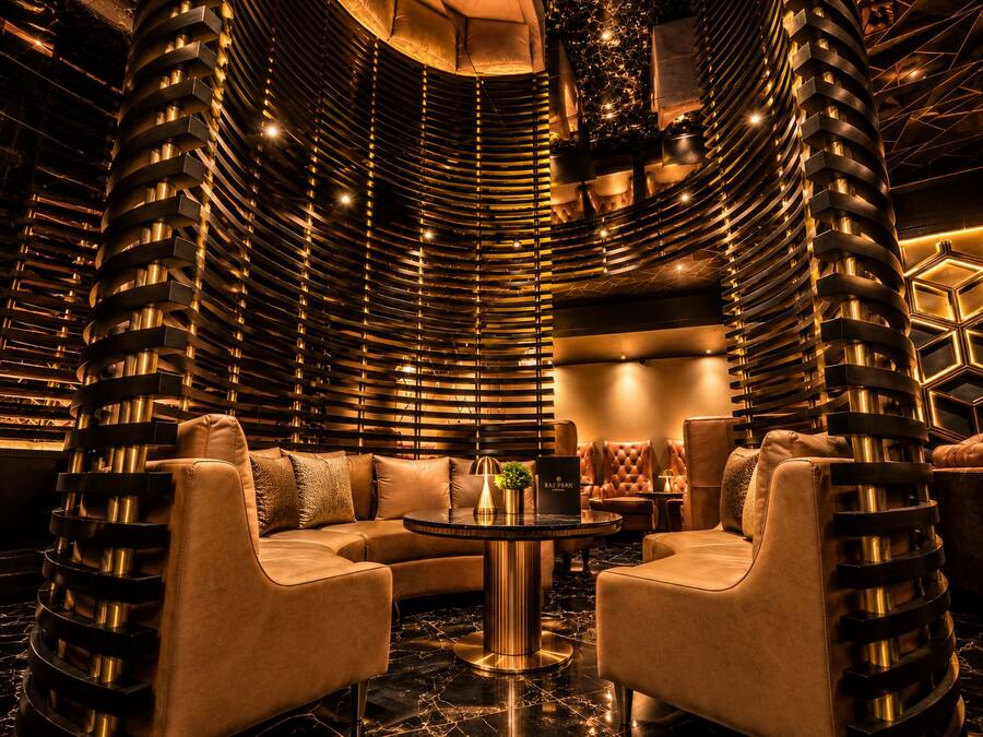 A luxurious interior with a curved wall design, a round table, and leather seating.