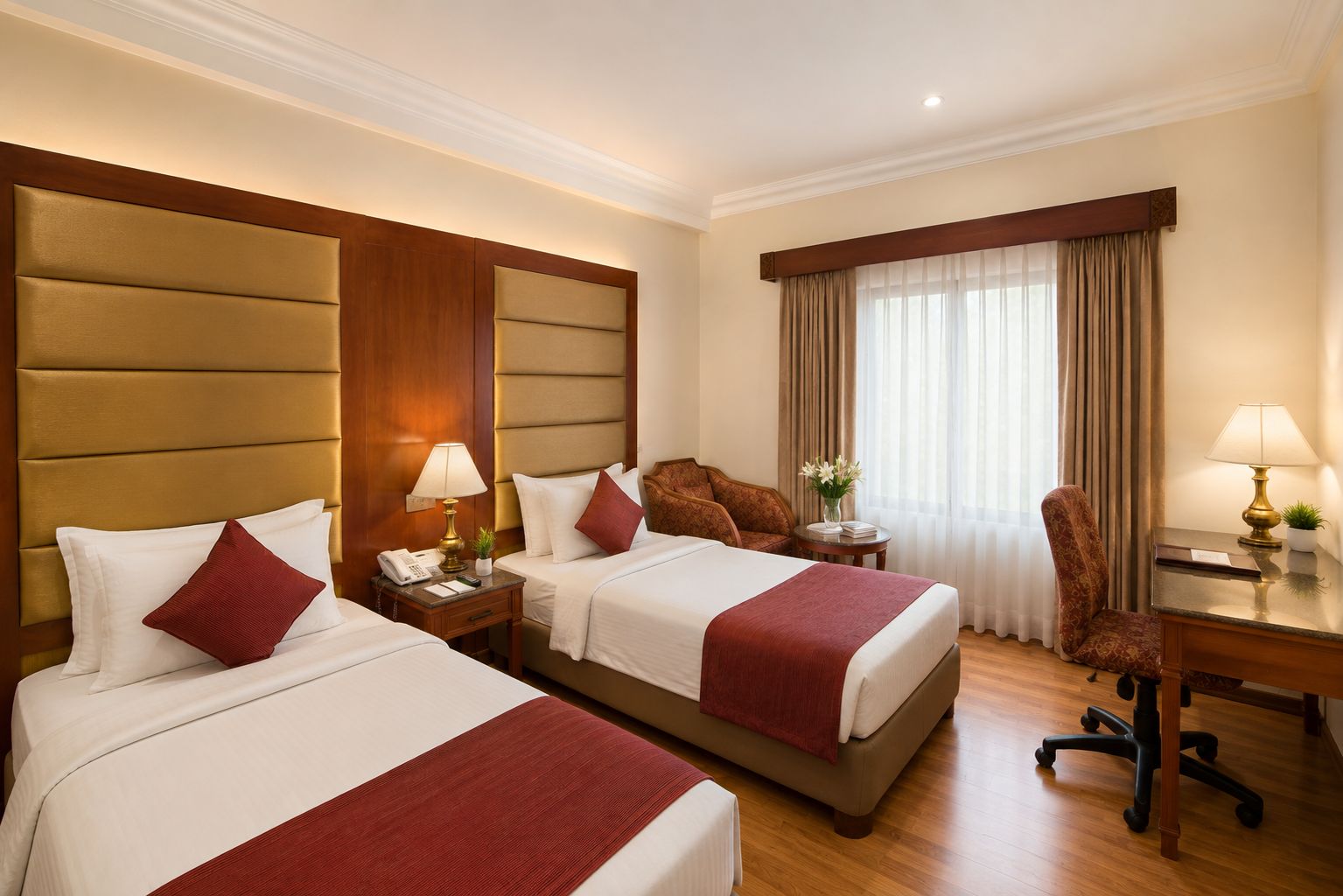 A hotel room with two beds, a desk, a chair, a lamp, and a window with curtains.