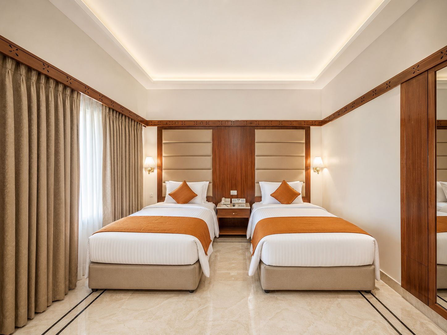 Habitación de hotel con dos camas, cabecera de madera, mesita de noche y espejo.