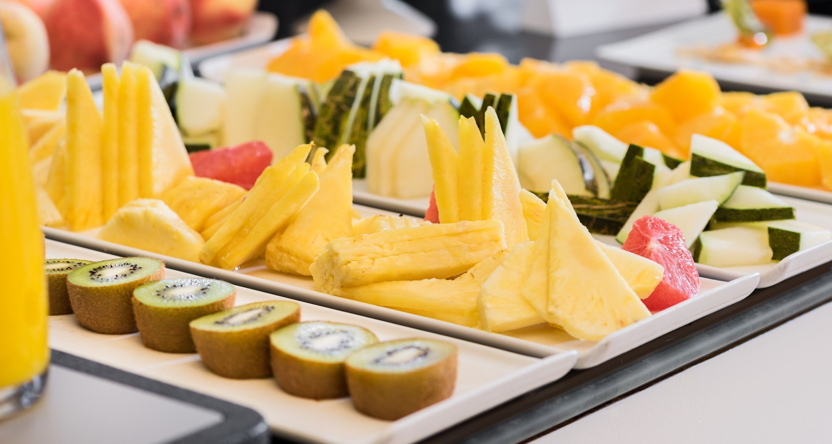 Un bufé con diversas frutas y plátanos en rodajas.