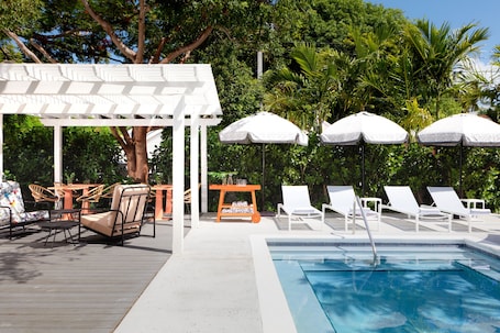 Una piscina al aire libre, sillones reclinables de piscina