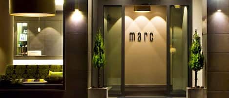 A modern building entrance with the name 'marc' displayed prominently.