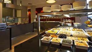 A buffet area with various food items and a glass display case. - marc münchen - Adults Only (Munich)
