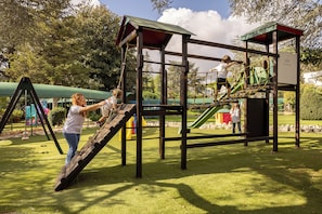 A playground with a wooden climbing structure and a slide. - Hotel Sierra Silvana (Fasano)
