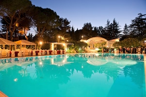 Una piscina al aire libre de temporada, sombrillas