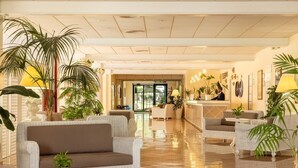 A spacious lobby with a reception desk, comfortable seating, and potted plants. - Hotel Sierra Silvana (Fasano)