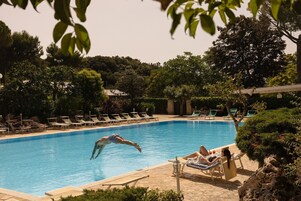 Una piscina al aire libre de temporada, sombrillas