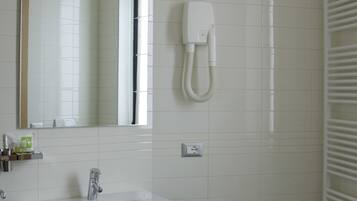 Une salle de bain moderne avec un grand miroir, un lavabo, un bidet et un porte-serviettes.