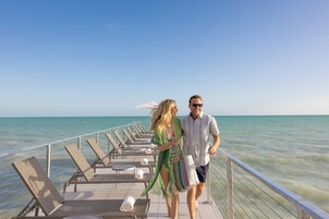 En la playa, sillas reclinables de playa, sombrillas, toallas de playa