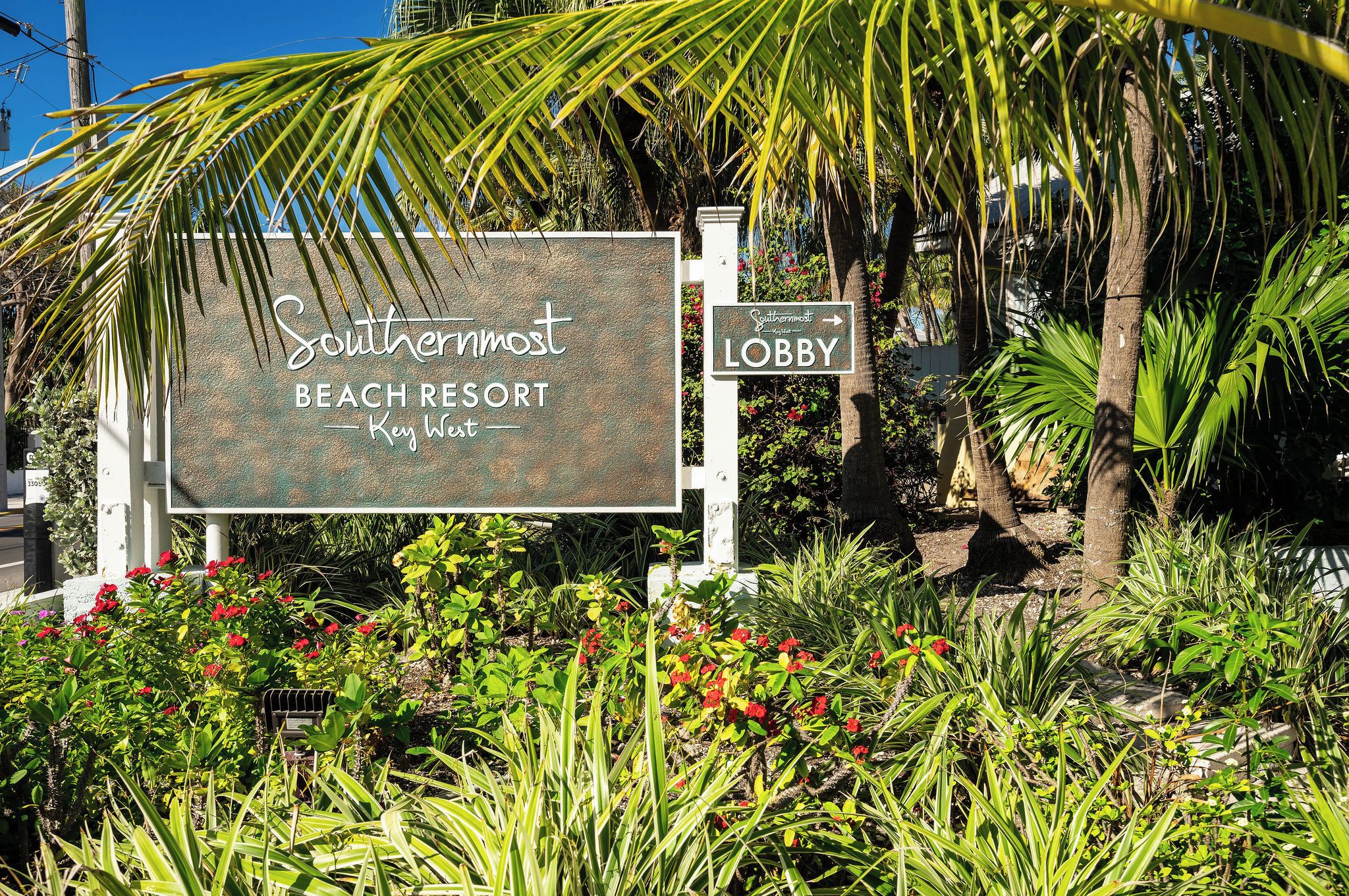 A sign for Southernmoist Beach Resort in Key West, with a directional sign to the lobby.