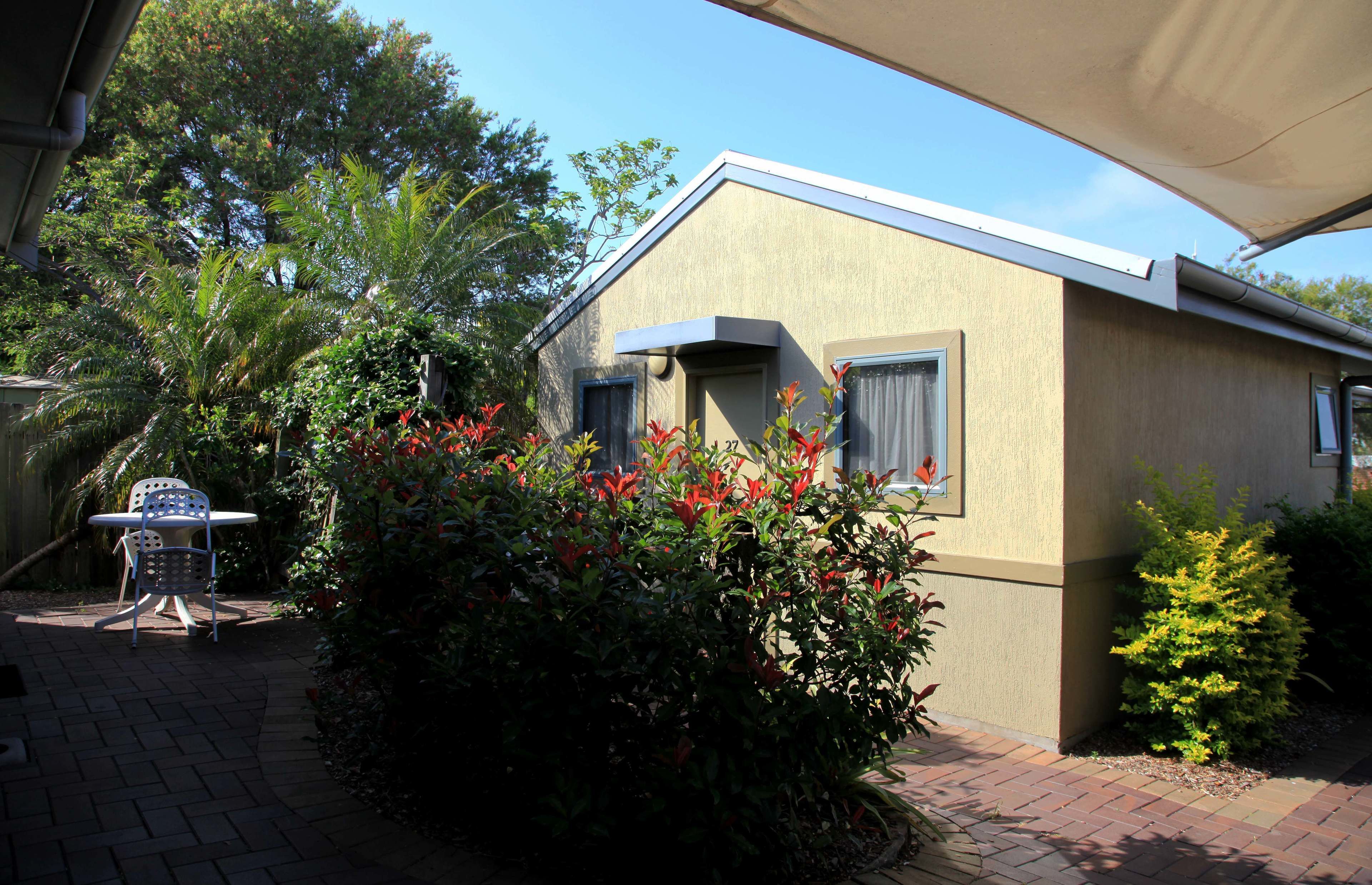 A small, single-story building with a flat roof and a covered patio area.