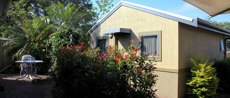 A small, single-story building with a flat roof and a covered patio area.