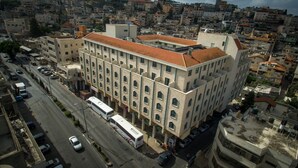 A multi-story building with a central courtyard, surrounded by a dense urban area. - Mary's Well Nazareth By Dan Hotels (Nazareth)