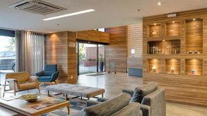 A lobby with a reception desk, seating area, and a display of decorative items. - Quality Suites Vila Velha (Vila Velha)