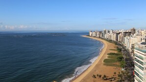 A coastal cityscape with a beach, high-rise buildings, and clear skies. - Quality Suites Vila Velha (Vila Velha)
