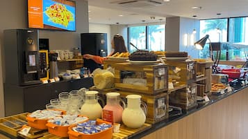 Um buffet de café da manhã com diversas opções de comida e um visor de menu digital.