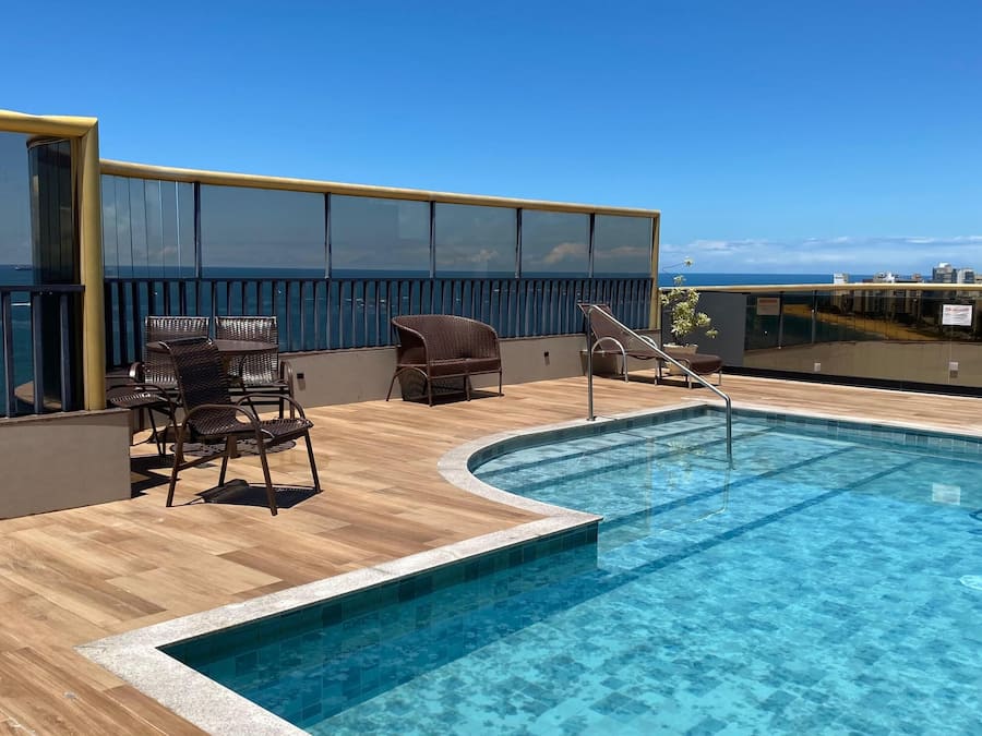 Una piscina al aire libre, sillones reclinables de piscina