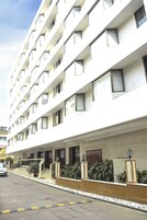 A multi-story hotel with a clean facade, multiple balconies, and a central entrance with steps.