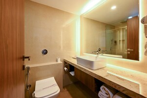 A modern bathroom with a toilet, sink, and shower.