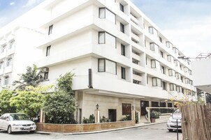 A multi-story hotel with a modern design, featuring a prominent entrance with steps and a sign indicating private parking.