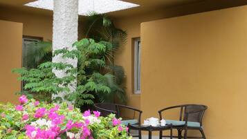 An outdoor seating area with a table and chairs, surrounded by plants and flowers.