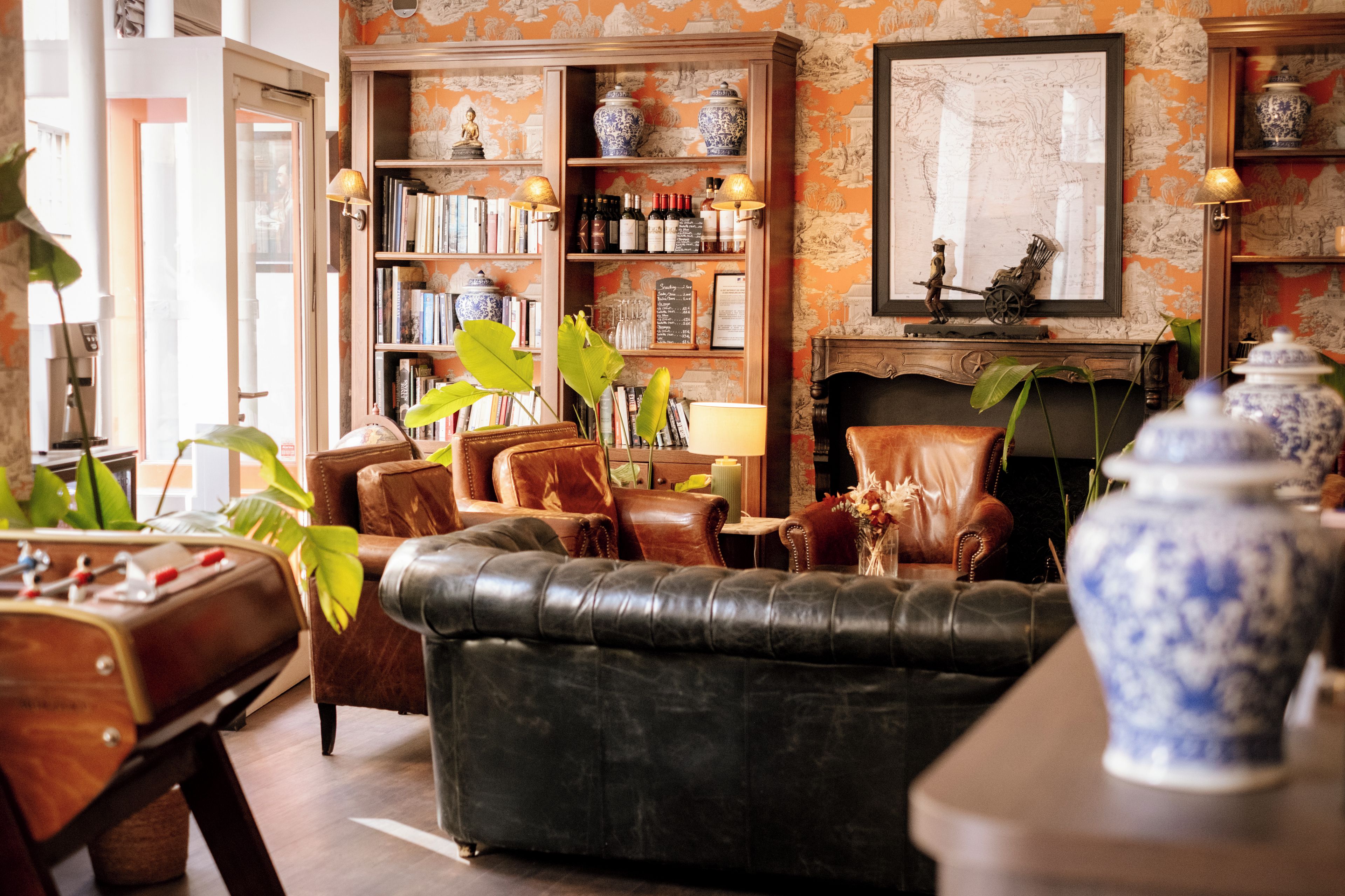 A traditional living room with leather furniture, a bookshelf, and decorative items.