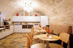 Un intérieur rustique avec un plafond en pierre, des meubles de rangement blancs et des meubles en bois.