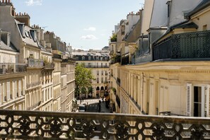 A narrow street with buildings on either side, balconies, and a clear sky. - Hôtel R. Kipling by Happyculture (Paris)