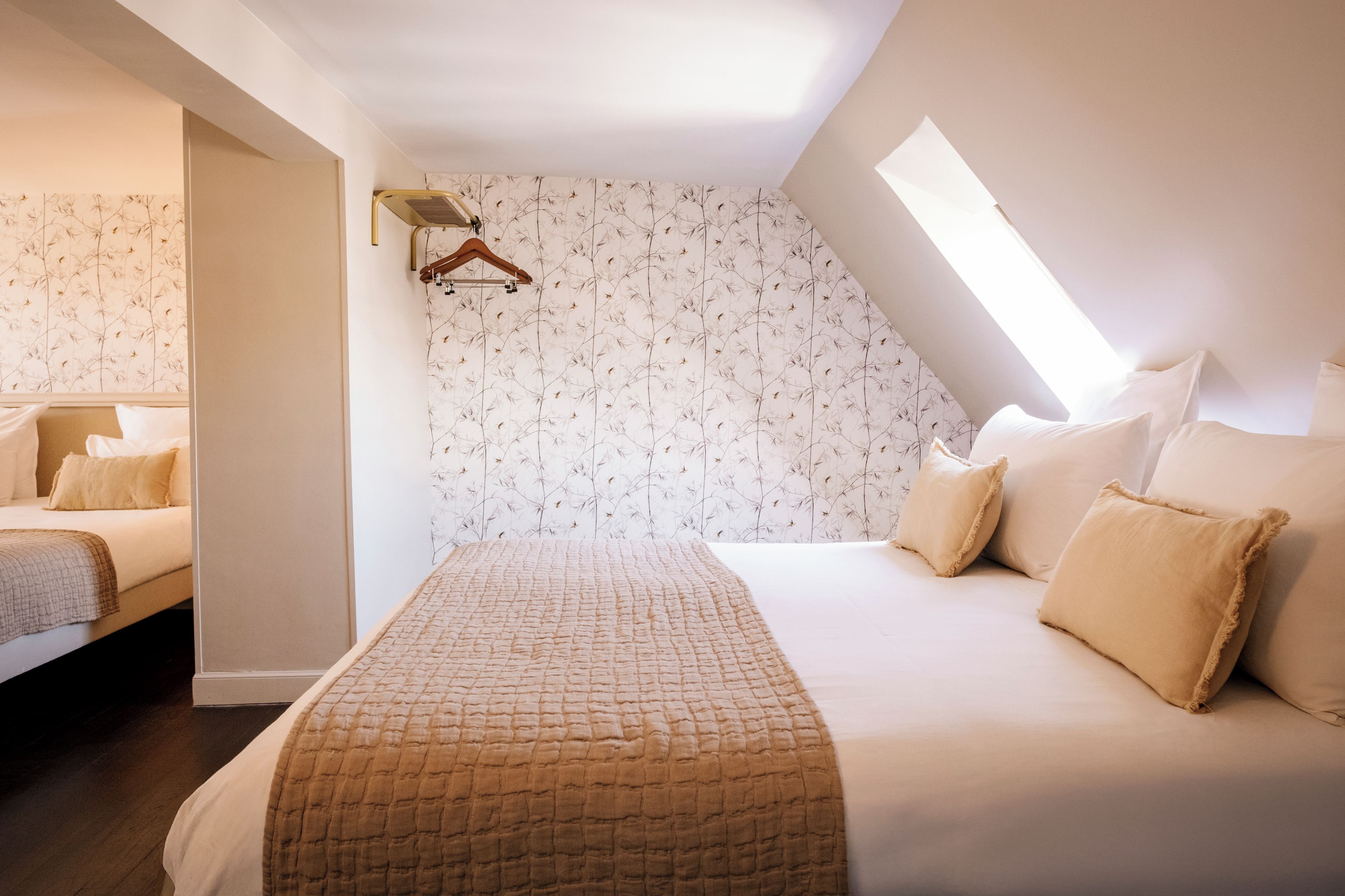 Un dormitorio con una cama grande, una lámpara colgante y un tragaluz.