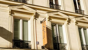 A building facade with classical architectural details, including columns and decorative moldings. - Hôtel R. Kipling by Happyculture (Paris)