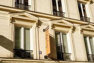 Μια πρόσοψη κτιρίου με κλασικά αρχιτεκτονικά στοιχεία, όπως κολόνες και διακοσμητικά γείσα.