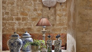 A stone wall with decorative vases and a table lamp. - Hôtel R. Kipling by Happyculture (Paris)