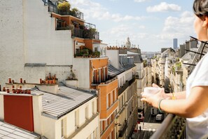 A high-rise building with multiple balconies, some with plants. - Hôtel R. Kipling by Happyculture (Paris)