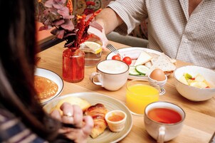 A breakfast table with various food items and drinks.