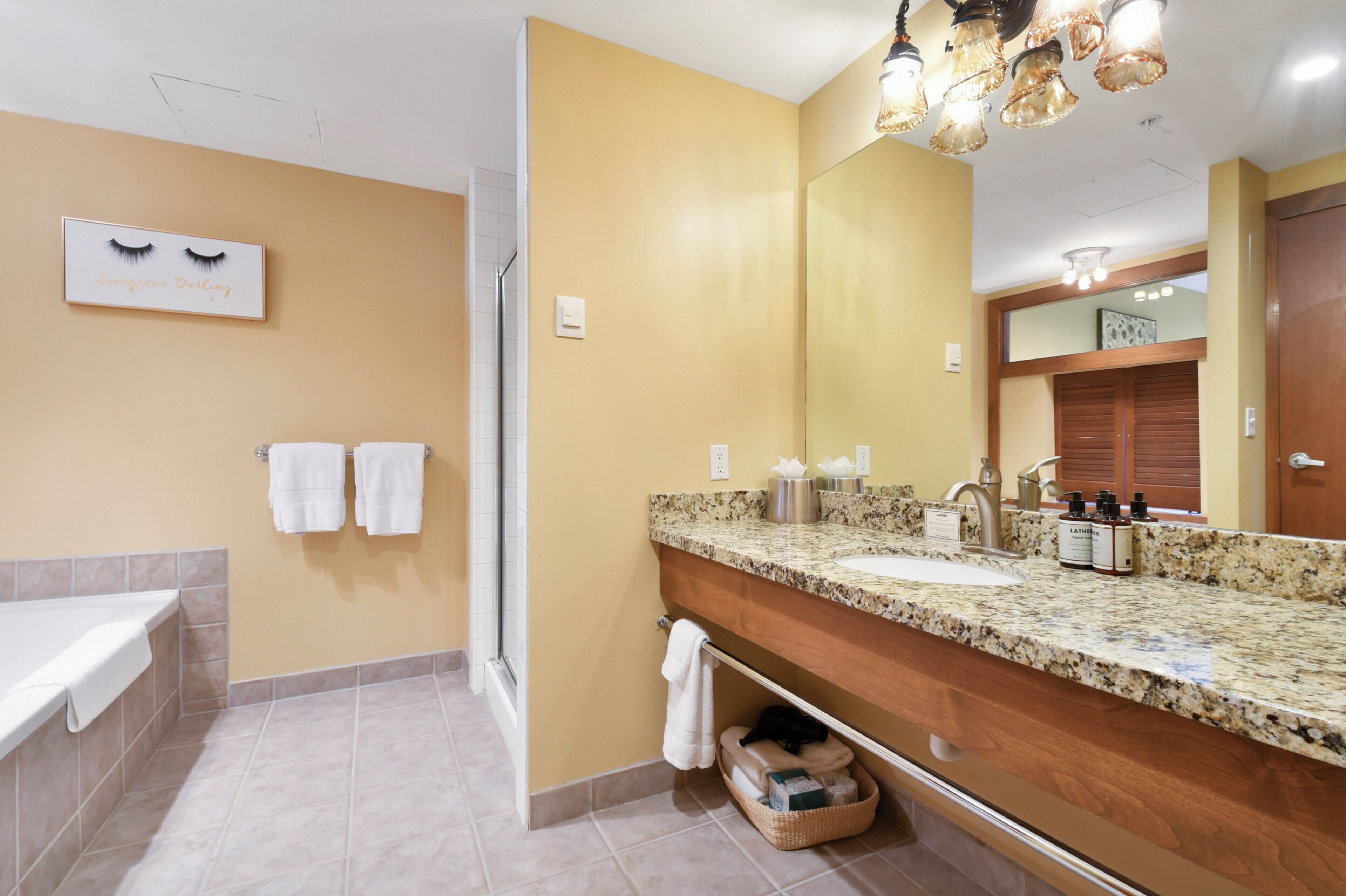 Baño con tocador de doble lavabo, espejo grande y zona de ducha.