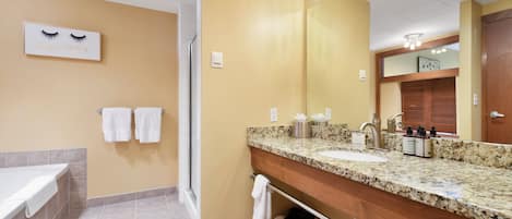 Baño con tocador de doble lavabo, espejo grande y zona de ducha.