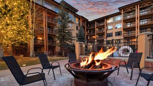 A courtyard with a fire pit, outdoor seating, and a Christmas tree.