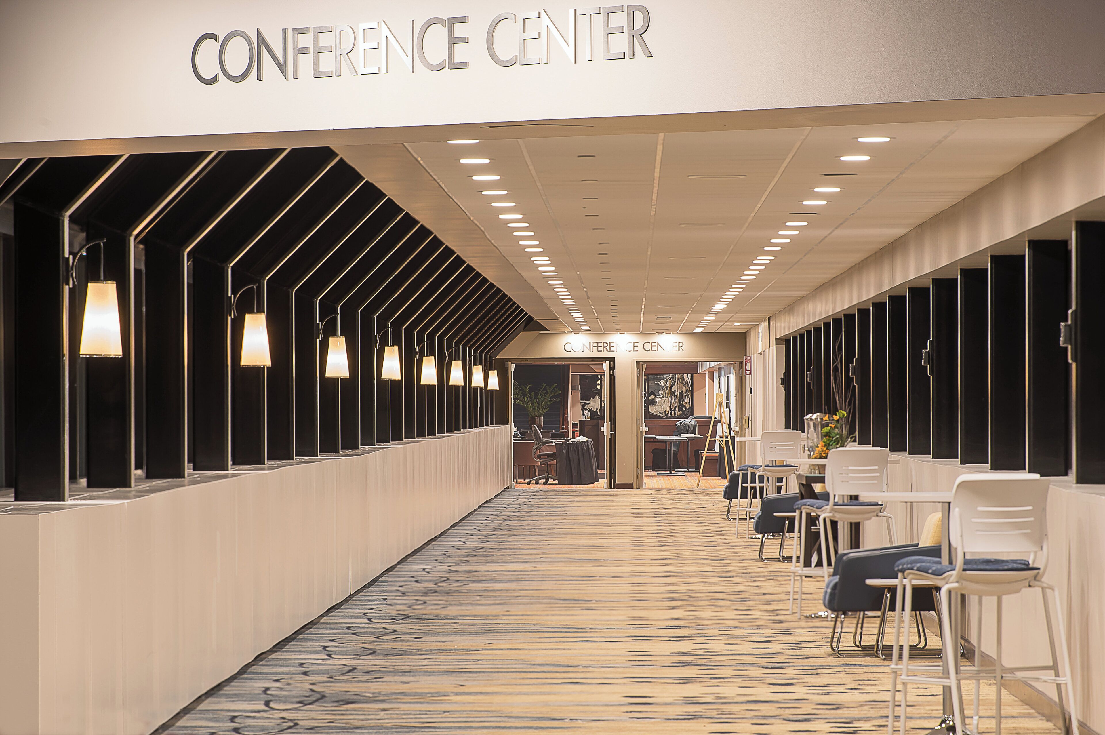 A conference center with a long corridor, seating area, and a reception desk.